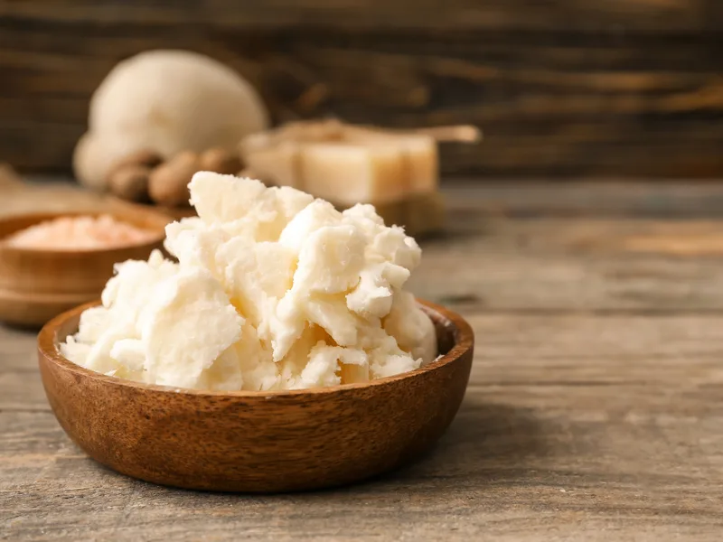 Unrefined shea butter chunks in a wooden bowl